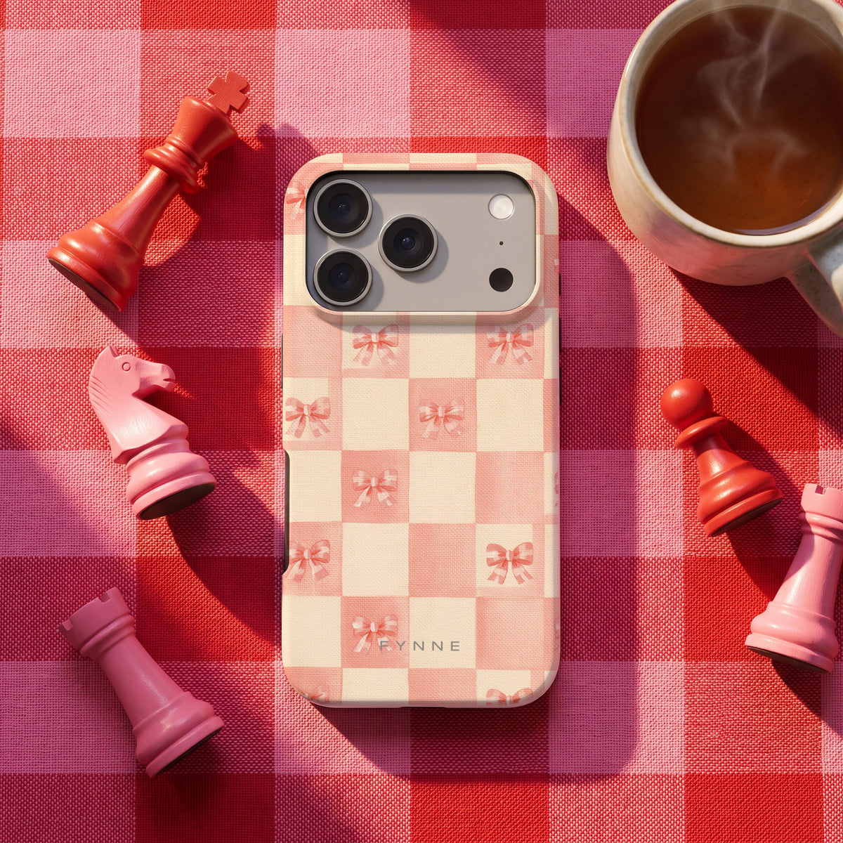 Roze strikjesgeruit hoesje op een iPhone 17 Pro, uit The Chess Collection